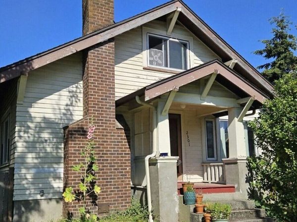 Craftsman bungalow with chalky siding and faded trim before repainting